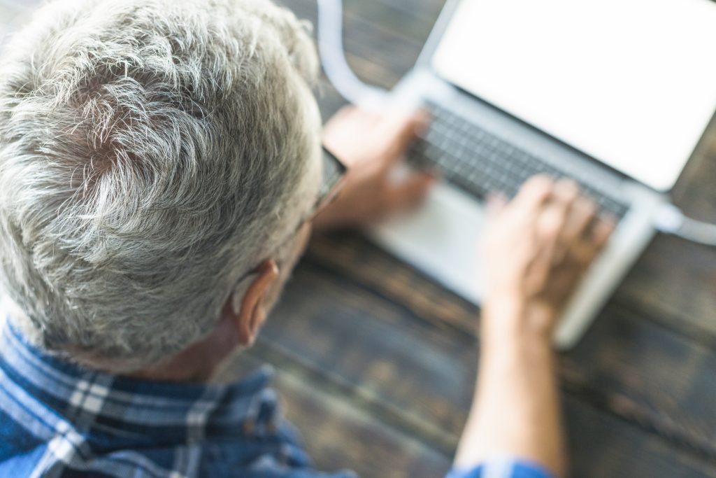 visao-aerea-homem-senior-usando-laptop