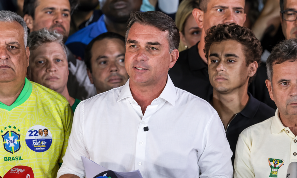 Coletiva de imprensa com multidão ao fundo
